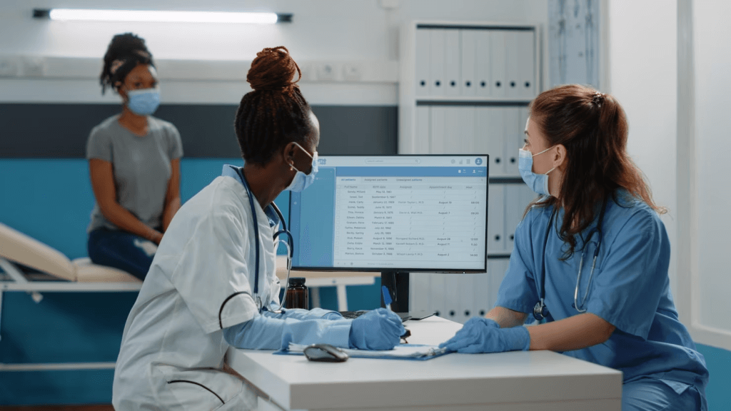 Doctor and nurse preparing prescription paper for patient at annual checkup visit.