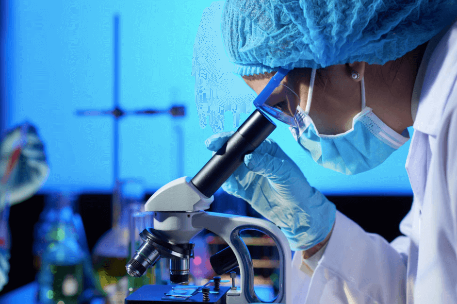 A medical student of Pakistan in the UK examining a sample under a microscope as part of their medical education.