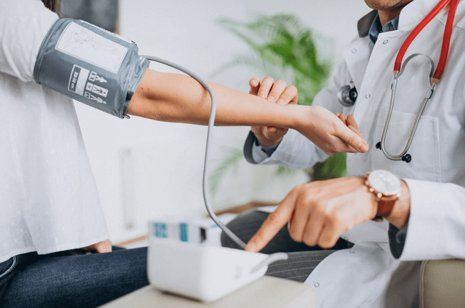 Pakistani medical student measuring blood pressure of a patient in the UK, highlighting diversity in healthcare education.