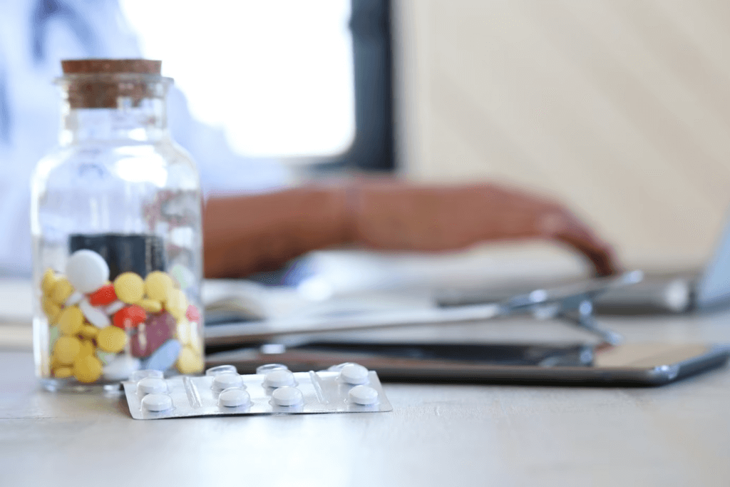 Medicine in a medical office setting, with a stethoscope and a clipboard on the desk.