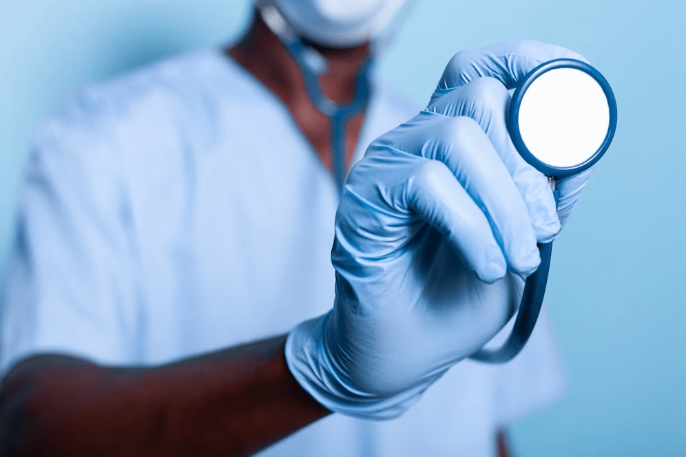 Close-up of a hand holding a stethoscope, representing medical education for Indians in the UK.