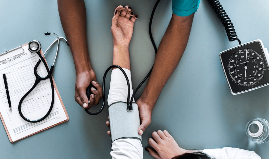 Indian medical student in the UK measuring a patient's blood pressure as part of their medical education journey.