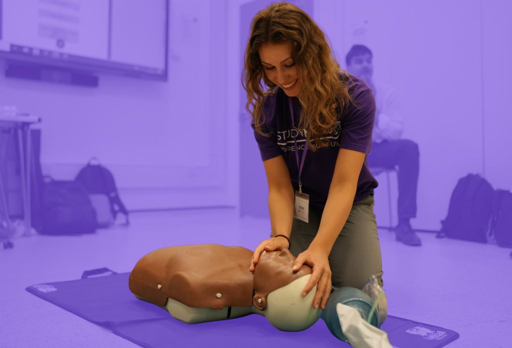 Student learning how to do CPR on a dummy.