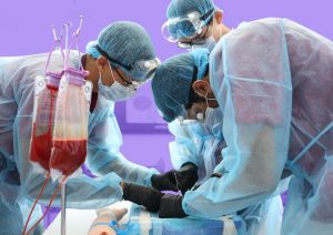Three students in a surgical simulation wearing gowns and using forceps.